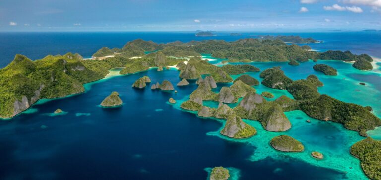 Pulau-pulau karst Wayag di Raja Ampat dengan laut biru jernih, dilihat dari udara.