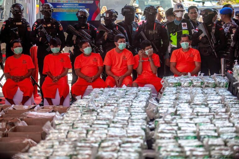 Tersangka kasus narkoba duduk di depan barang bukti sabu yang disita aparat.