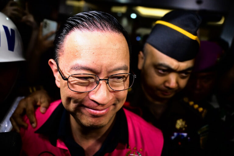 Tom Lembong mengenakan rompi tahanan merah muda dikawal petugas.